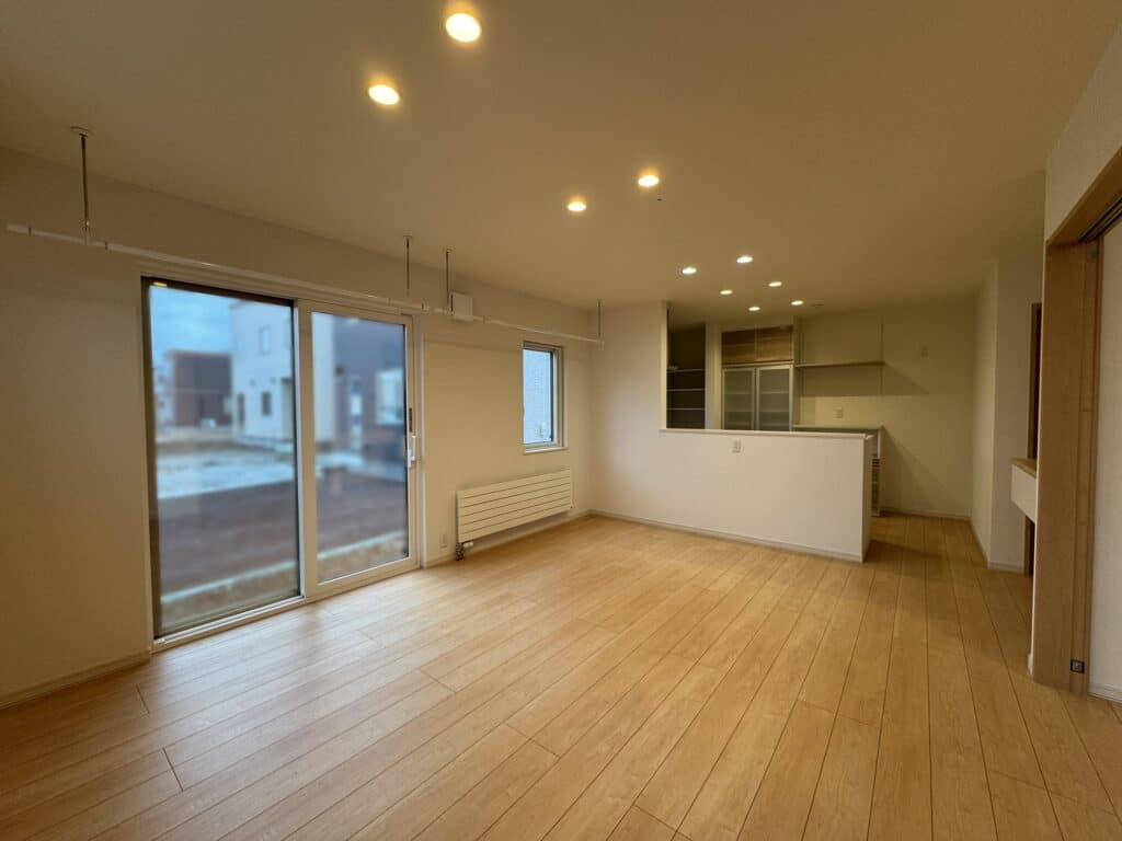 大きな窓から自然光が差し込む対面キッチンの明るいLDK