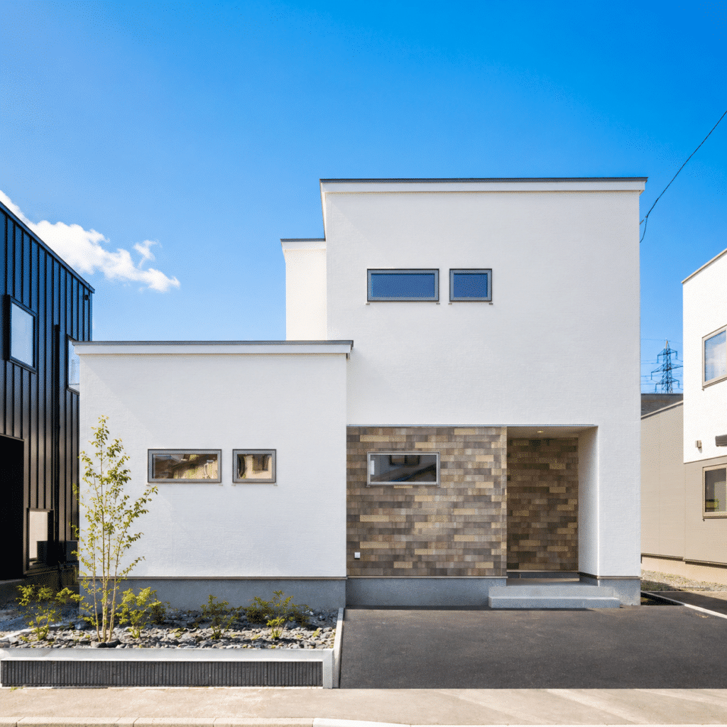 白い外壁と木目調タイルが特徴的な注文住宅の正面外観