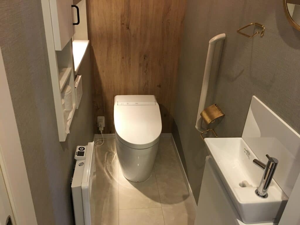 収納棚と手洗い器を備えたトイレ