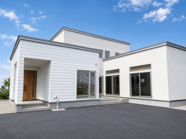 白い外壁と木製玄関ドアが印象的な新築住宅の外観