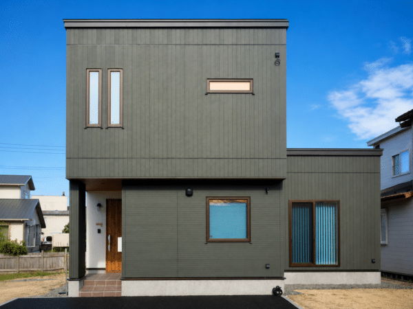 縦長の窓と横長の窓を配した二階建て住宅の正面外観