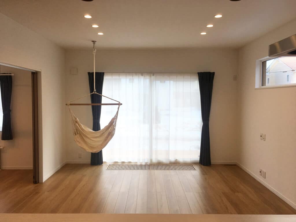 大きな窓とハンモックがある洋室